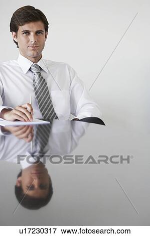 Business man sitting at conference table, portrait View Large Photo Image Stock Photo - Business man sitting at conference table, portrait. Fotosearch
