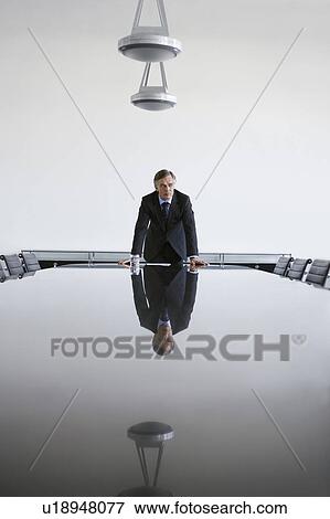 Stock Photo - Business man standing at conference table. Fotosearch