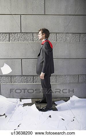 Business man surrounded by paper material, beside wall View Large Photo Image Stock Image - Business man surrounded by paper material, beside wall. Fotosearch