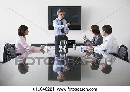 Stock Image - Business man talking to colleagues in conference meeting. Fotosearch