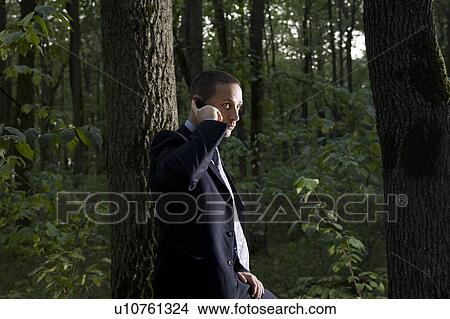 Business man using mobile phone in forest View Large Photo Image Picture - Business man using mobile phone in forest. Fotosearch