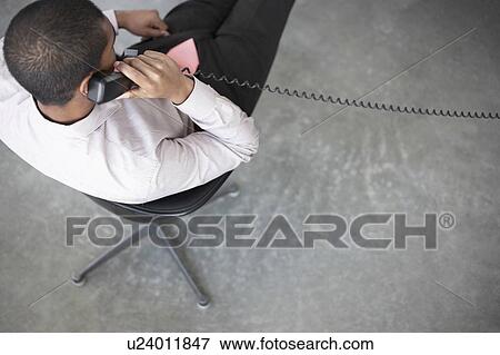 Business man using phone in office, view from above View Large Photo Image Stock Photo - Business man using phone in office, view from above. Fotosearch