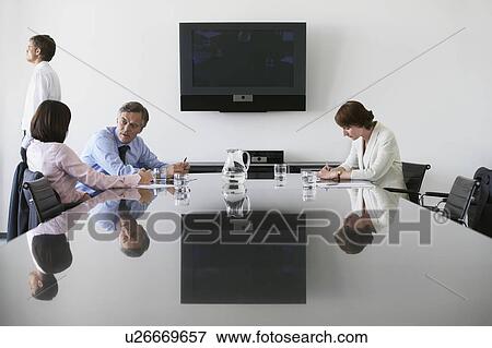 Business man walking away from colleagues in conference room View Large Photo Image Stock Photo - Business man walking away from colleagues in conference room. Fotosearch
