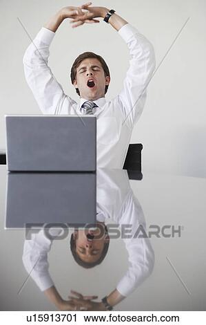 Business man with laptop, yawning at conference table View Large Photo Image Stock Image - Business man with laptop, yawning at conference table. Fotosearch