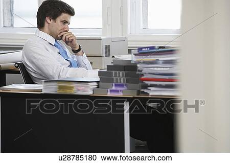 Business man working at desk in office View Large Photo Image Stock Image - Business man working at desk in office. Fotosearch