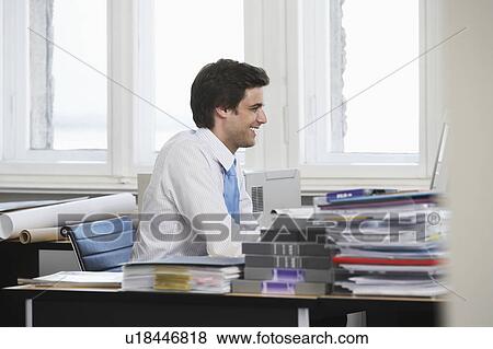 Business man working at desk in office, smiling View Large Photo Image Stock Photo - Business man working at desk in office, smiling. Fotosearch