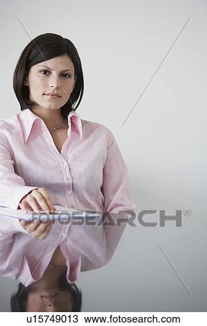 Stock Image - Business woman sitting at conference table, portrait. Fotosearch