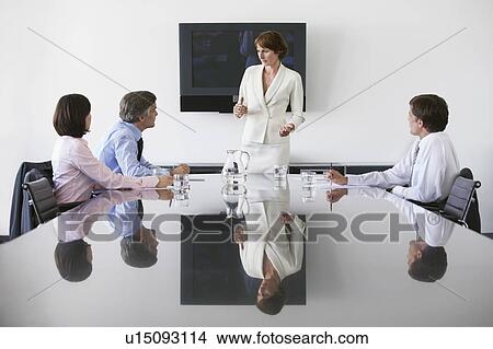 Picture - Business woman talking to colleagues in conference meeting. Fotosearch