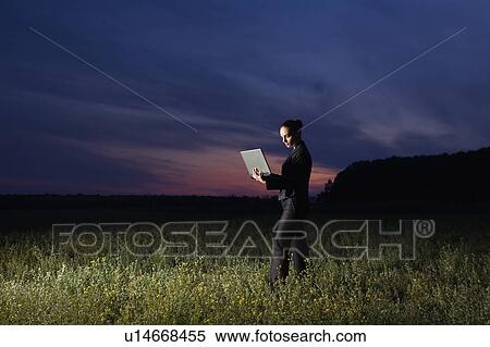 Business woman using laptop in field View Large Photo Image Stock Photography - Business woman using laptop in field. Fotosearch