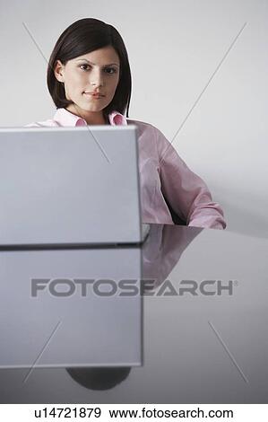 Stock Photo - Business woman with laptop at conference table, portrait. Fotosearch