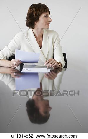 Stock Image - Business woman working at conference table. Fotosearch