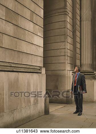 Stock Image - Businessman facing monumental building. Fotosearch