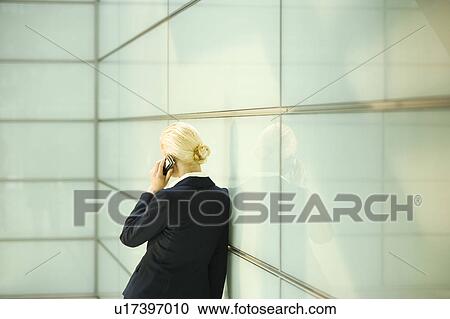 Stock Image - Businesswoman Using Cell Phone, back view. Fotosearch