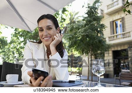 Businesswoman using mobile phone at outdoor cafe View Large Photo Image Stock Photography - Businesswoman using mobile phone at outdoor cafe. Fotosearch