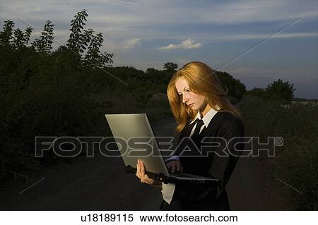 Stock Photography - Businesswoman with a Laptop on a Dirt Road. Fotosearch