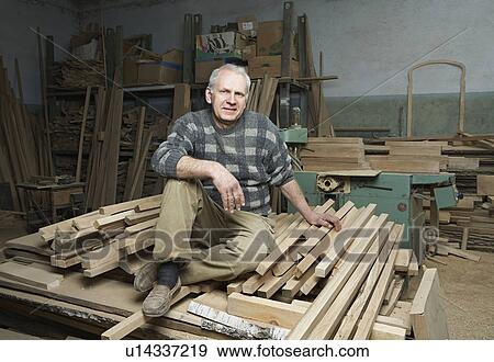Carpenter Sitting on Wood Stacked in Workshop View Large Photo Image Stock Photo - Carpenter Sitting on Wood Stacked in Workshop. Fotosearch