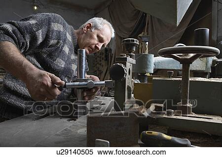 Stock Photography - Carpenter Working in Workshop. Fotosearch
