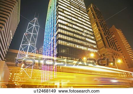 Stock Photo - China, Hong Kong, low angle view of illuminated skyscrapers (long exposure). Fotosearch