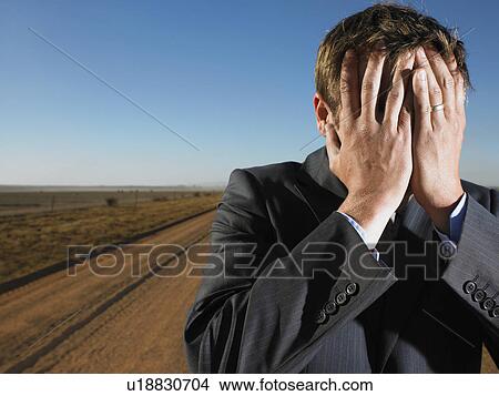 Picture - Close up of businessman with head in hands. Fotosearch