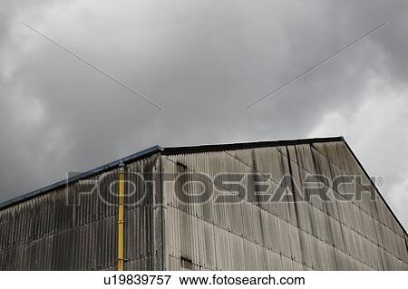Corrugated metal building exterior with yellow drainpipe View Large Photo Image Stock Photo - Corrugated metal building exterior with yellow drainpipe. Fotosearch