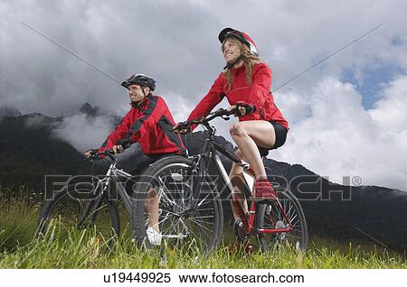 Couple cycling in countryside View Large Photo Image Stock Photography - Couple cycling in countryside. Fotosearch