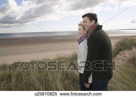 Stock Photography - Couple holding hands at ocean. Fotosearch