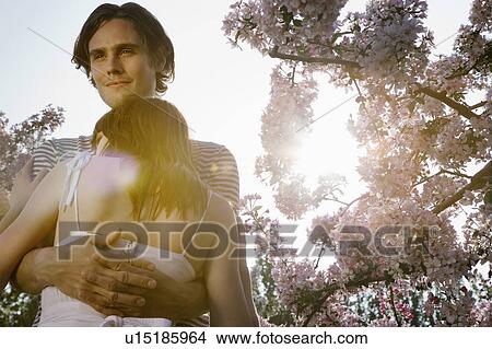 Picture - Couple Hugging in Orchard. Fotosearch