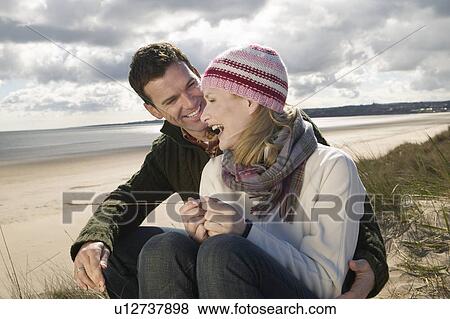 Stock Photo - Couple on beach, smiling. Fotosearch