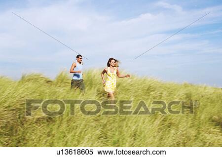 Stock Photography - Couple Running through Meadow. Fotosearch