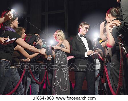 Couple signing autographs on red carpet View Large Photo Image Stock Photo - Couple signing autographs on red carpet. Fotosearch