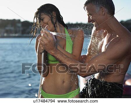 Picture - Couple Spraying Hose. Fotosearch