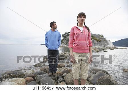Couple standing on rocks at ocean View Large Photo Image Stock Photo - Couple standing on rocks at ocean. Fotosearch