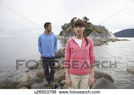 Couple standing on rocks at ocean View Large Photo Image Stock Photo - Couple standing on rocks at ocean. Fotosearch