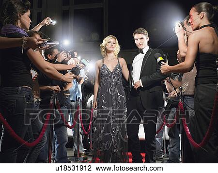 Couple walking down red carpet, journalists around View Large Photo Image Stock Image - Couple walking down red carpet, journalists around. Fotosearch