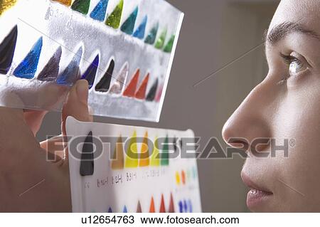 Stock Image - Craftswoman makes a visual selection of stained glass. Fotosearch