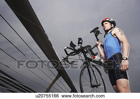 Cyclist carrying bicycle on foot bridge, low angle view View Large Photo Image Stock Photograph - Cyclist carrying bicycle on foot bridge, low angle view. Fotosearch