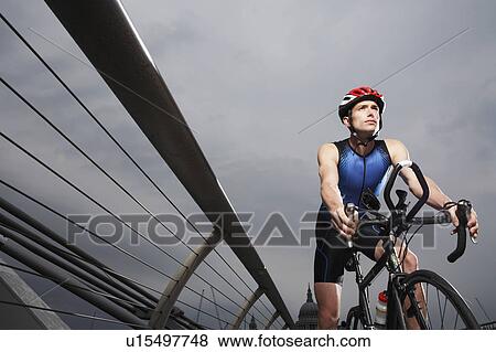 Cyclist riding on foot bridge, low angle view View Large Photo Image Stock Photo - Cyclist riding on foot bridge, low angle view. Fotosearch