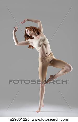 Stock Photography - Dancer stands on one leg stretching arms above head. Fotosearch