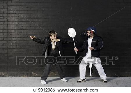 Stock Photography - Dressed up boys pretending to fight. Fotosearch