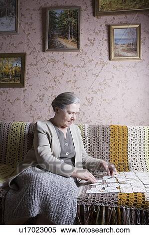 Elderly lady sits playing cards alone View Large Photo Image Stock Photography - Elderly lady sits playing cards alone. Fotosearch