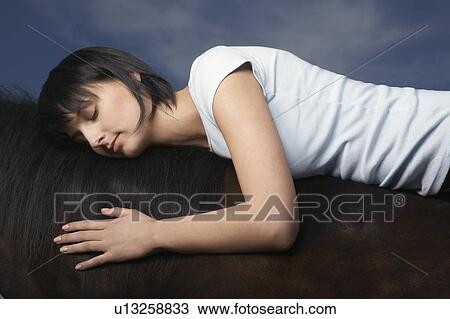 Stock Image - Equestrian Lying on Back of Horse. Fotosearch