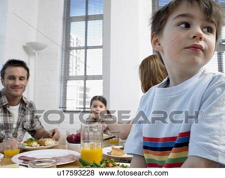 Stock Photo - Family with children (3-6) at dining room table. Fotosearch