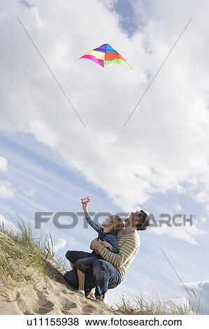 Father and daughter (5-6) flying kite on dunes View Large Photo Image Stock Photo - Father and daughter (5-6) flying kite on dunes. Fotosearch