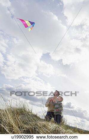 Father and daughter (5-6) flying kite on dunes View Large Photo Image Stock Photography - Father and daughter (5-6) flying kite on dunes. Fotosearch
