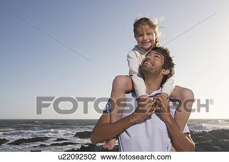 Father giving daughter piggyback, half length, in front of ocean View Large Photo Image Stock Image - Father giving daughter piggyback, half length, in front of ocean. Fotosearch
