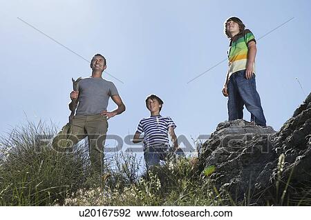 Father with two sons (7-9, 10-12) on mountain top, looking at view View Large Photo Image Stock Image - Father with two sons (7-9, 10-12) on mountain top, looking at view. Fotosearch
