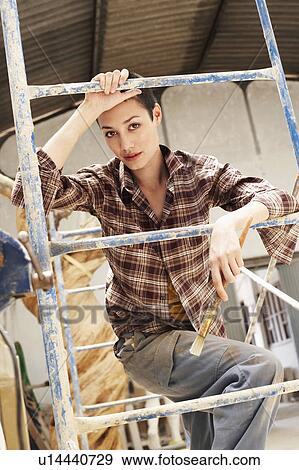Stock Photo - Female interior decorator leaning on Scaffolding, portrait. Fotosearch