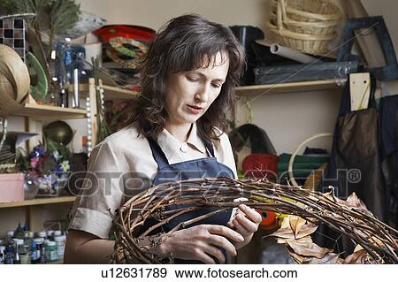 Stock Photo - Florist in shop making wreath. Fotosearch