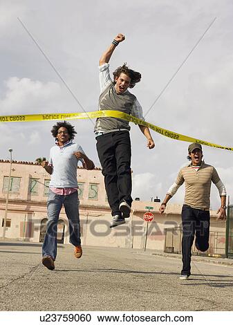 Stock Image - Friends racing to police tape in street. Fotosearch