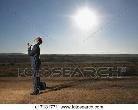 Stock Image - Frustrated businessman in middle of deserted road. Fotosearch